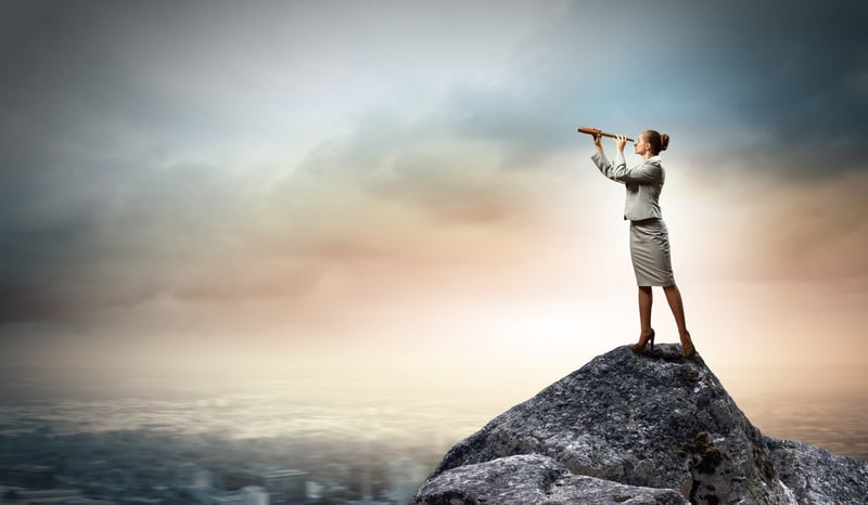 Image of businesswoman looking in telescope standing atop of rock